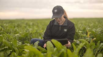 betaseed breeder in the field with a tablet